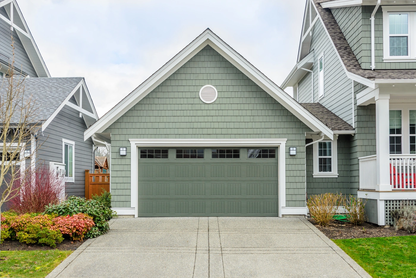 sleek garage with green siding and a gable roofing system