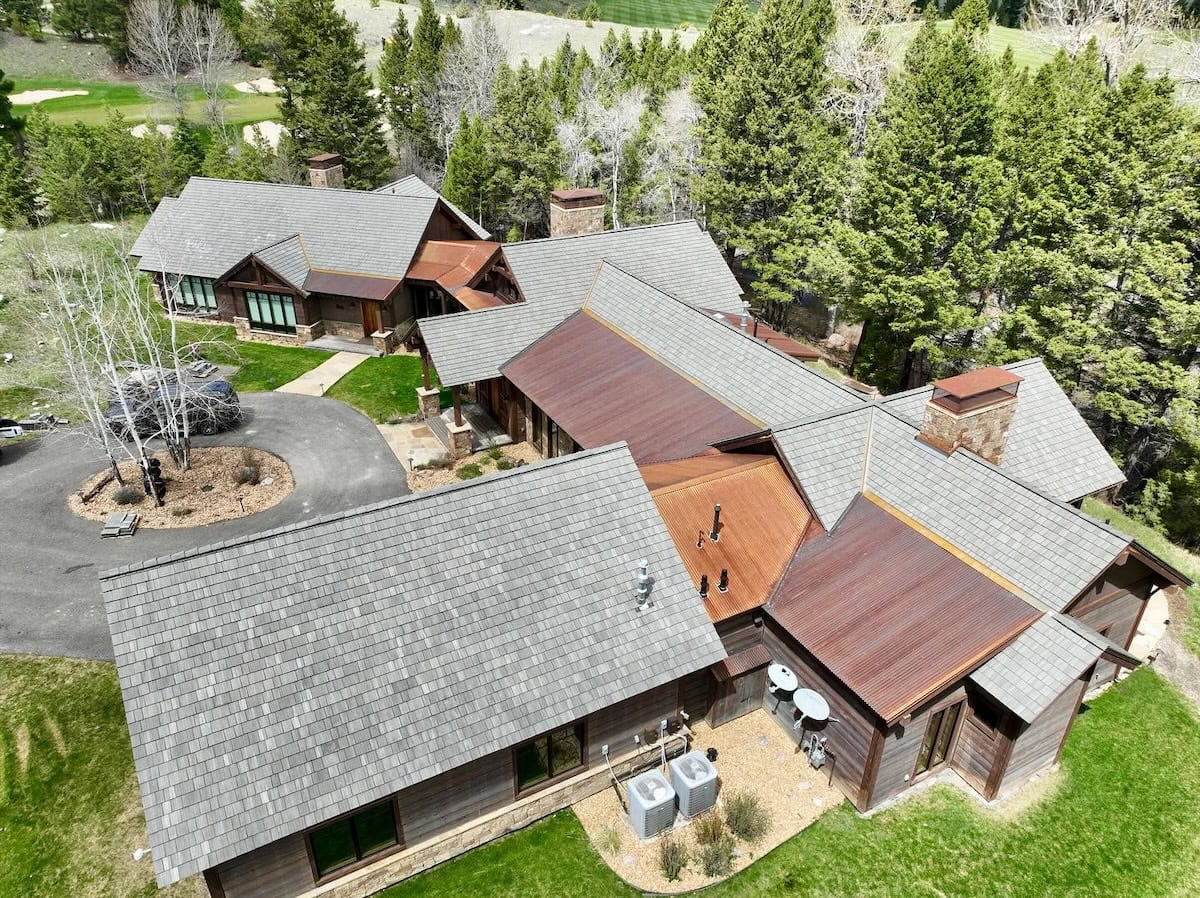 Large building with composite cedar shake roofing and metal accent roofing