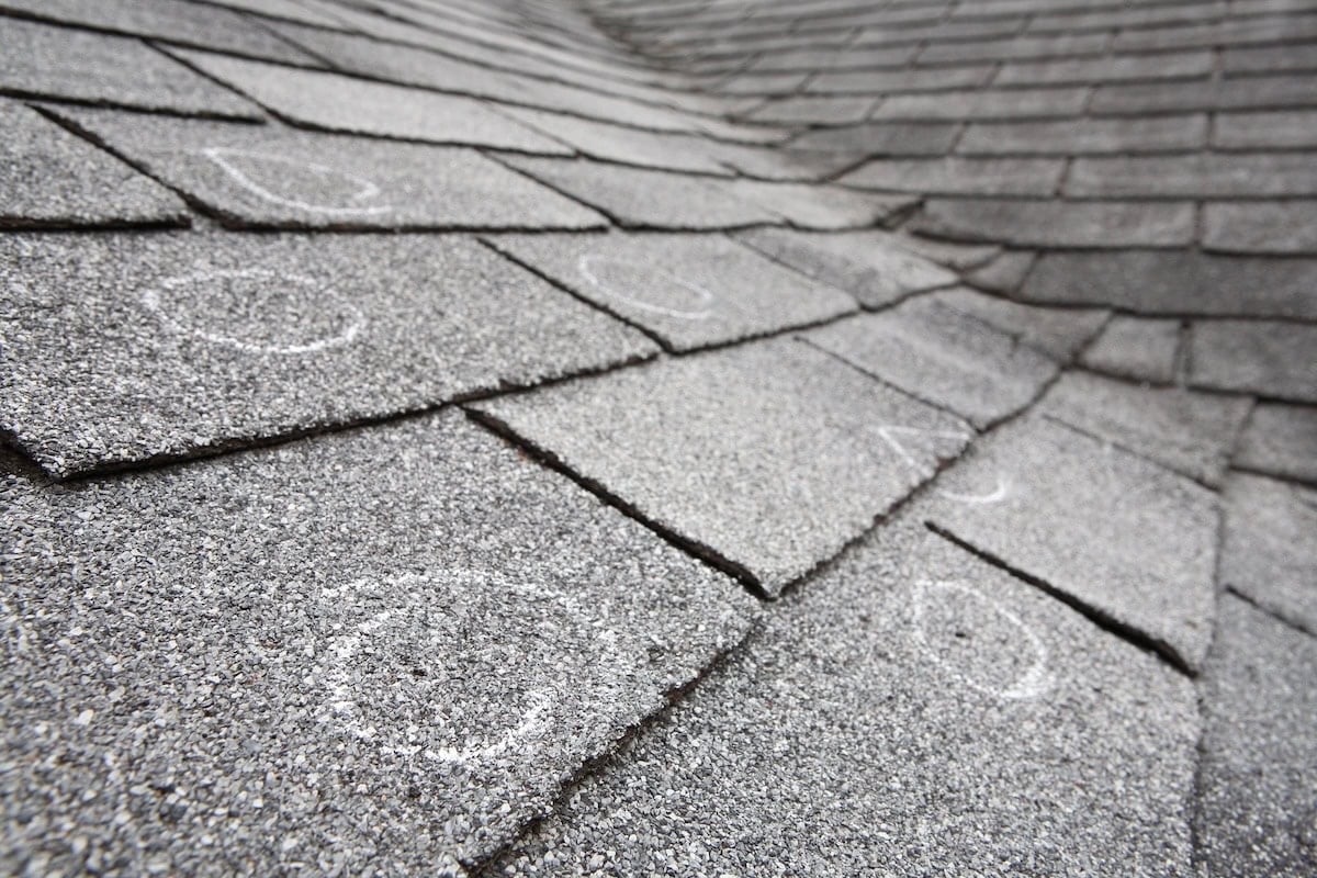 Old roof with hail damage marked with chalk after inspection