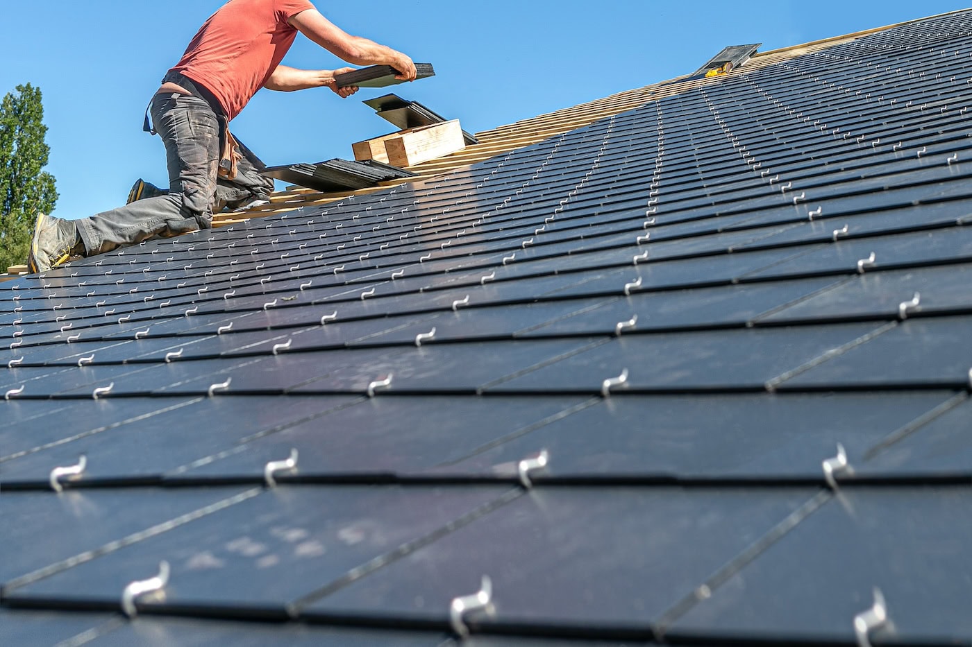 Craftsmen are installing a slate roof home.Professional roof workers repairing roof t.Working on rooftop.