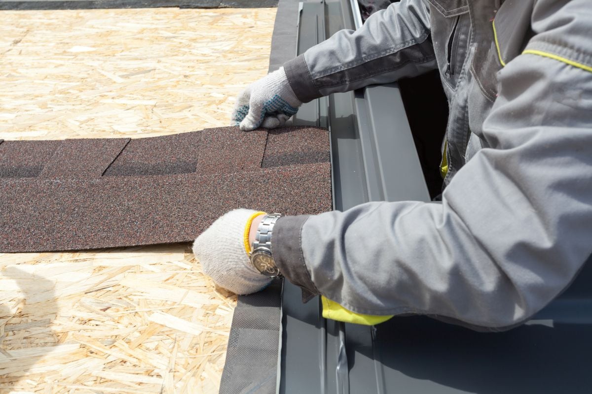 person installing shingles