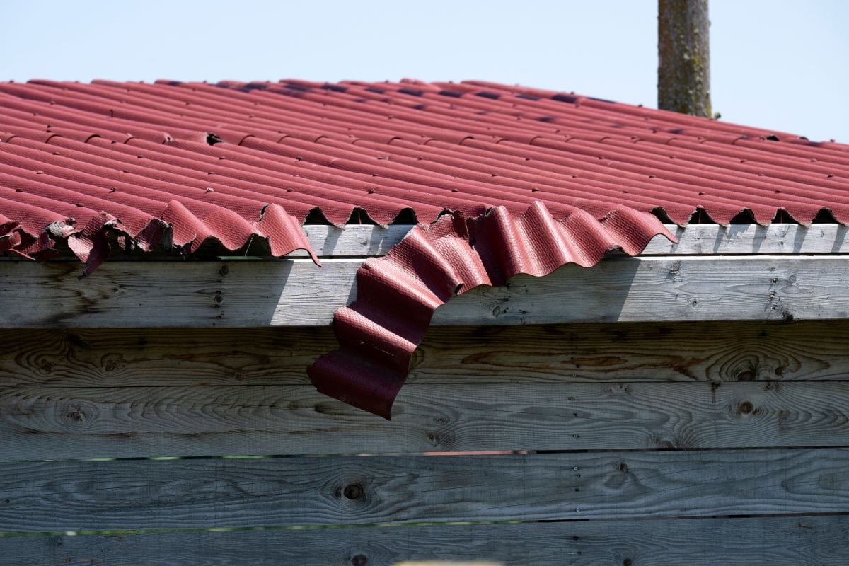 storm damage roof inspection red corrugated metallic roof damaged after storm