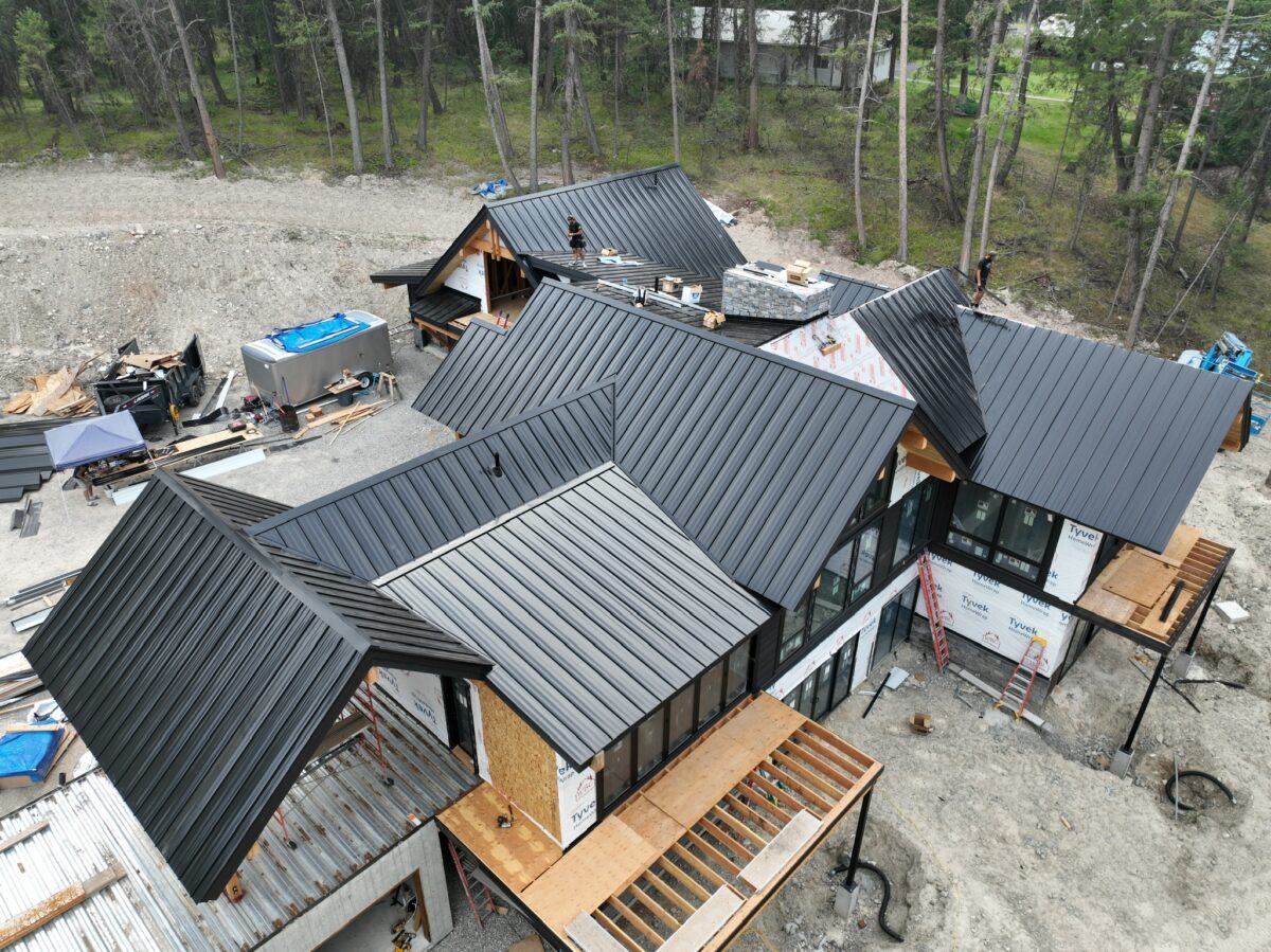 does a black roof make your house hotter huge metallic roof workers building new house Montana Roofing project