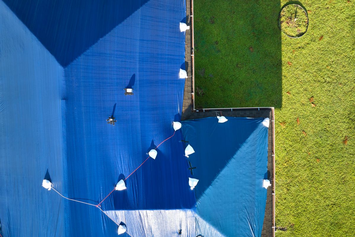 roof wind damage blue tarp on top of big house in Florida