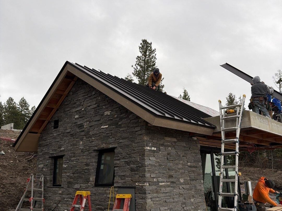 roof leak inspection worker on top of metallic roof