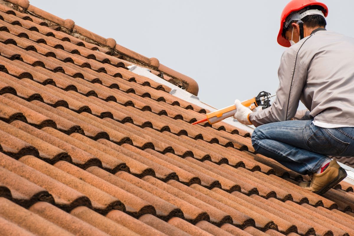 best roof sealant for leaks worker applying white sealant on ceramic tiles