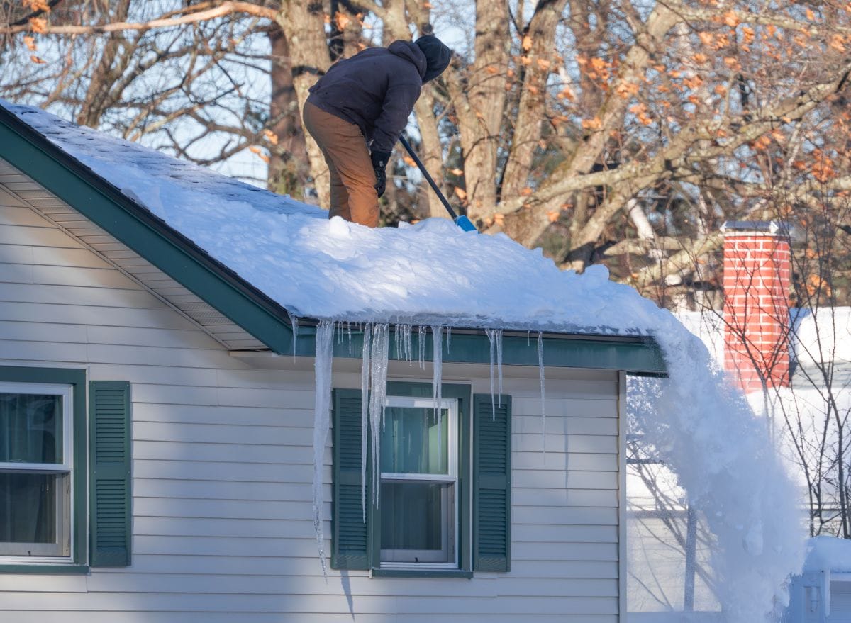 ice dam removal worker removing snow